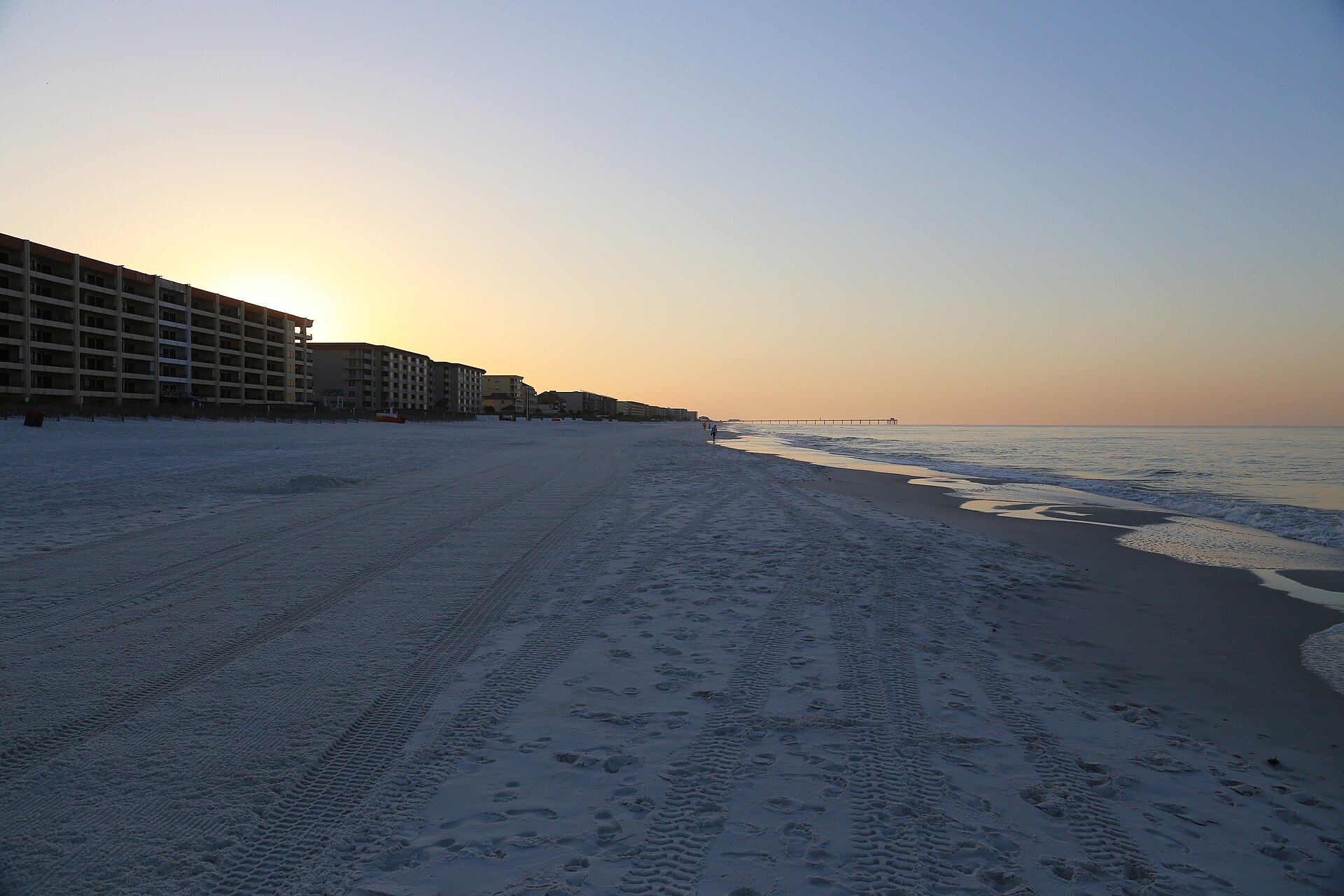 White-sand beach and pier at golden hour on the Emerald Coast, Florida